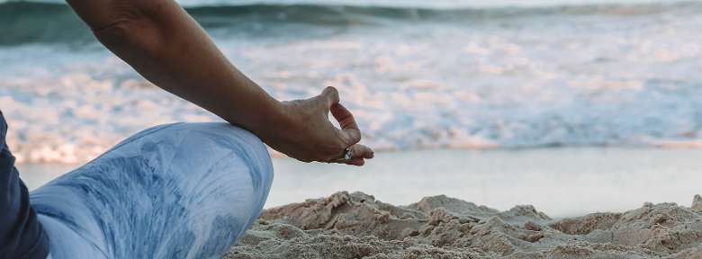 person meditating on the beach