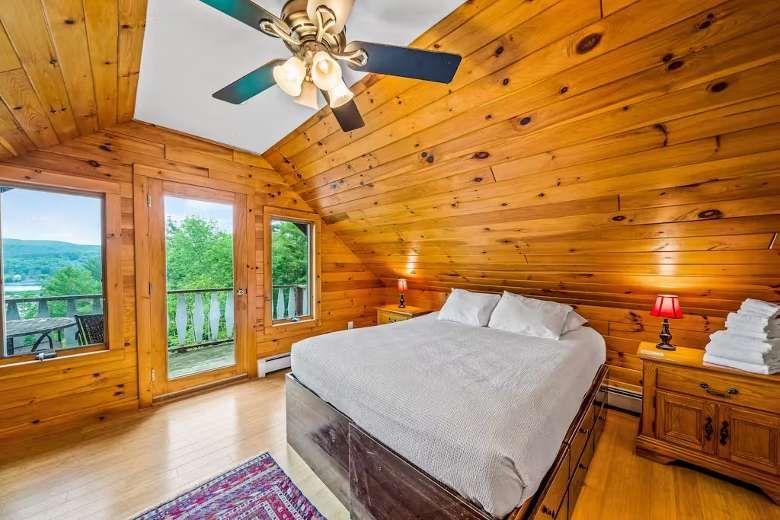 bedroom with balcony overlooking a lake