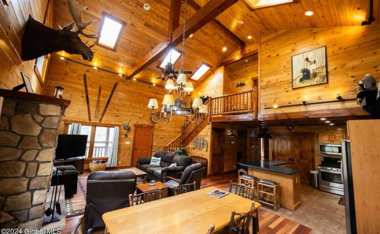 living room with moose above mantle and wooden vaulted ceiling