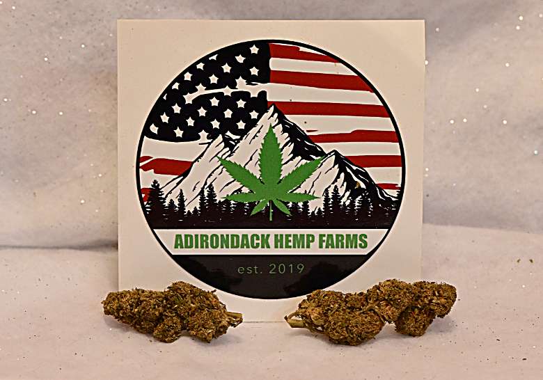 two hemp flowers and ADK Hemp sign