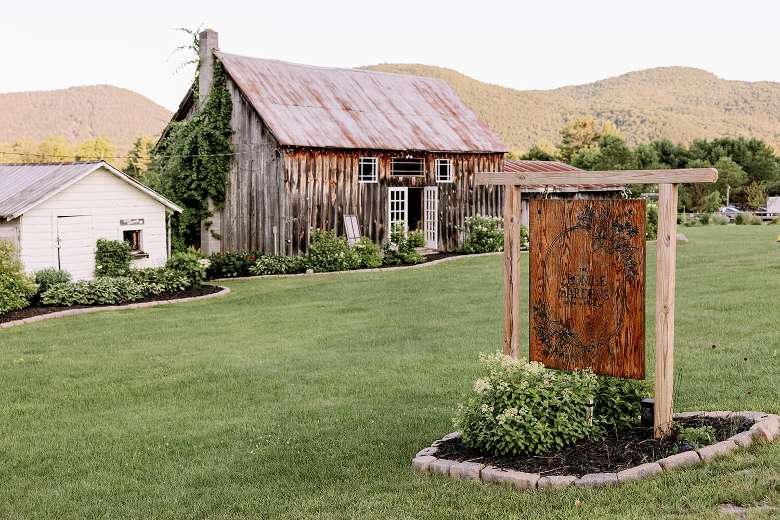 barns with business sign and mountains in the background