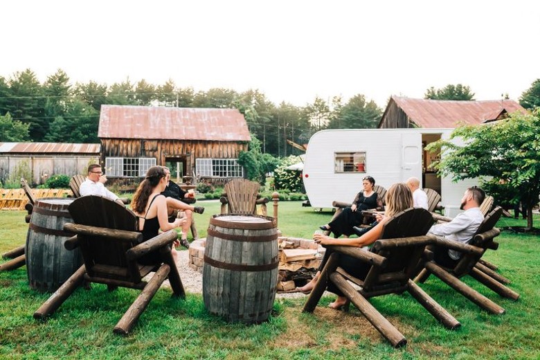 people around fire pit in adirondack chairs
