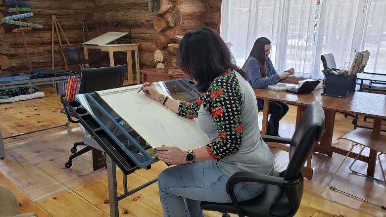 people working at desks in a log cabin