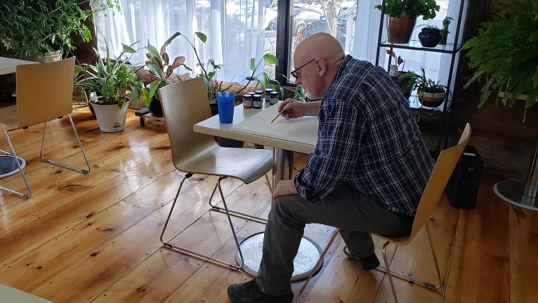 person working at a cafe desk in a log cabin