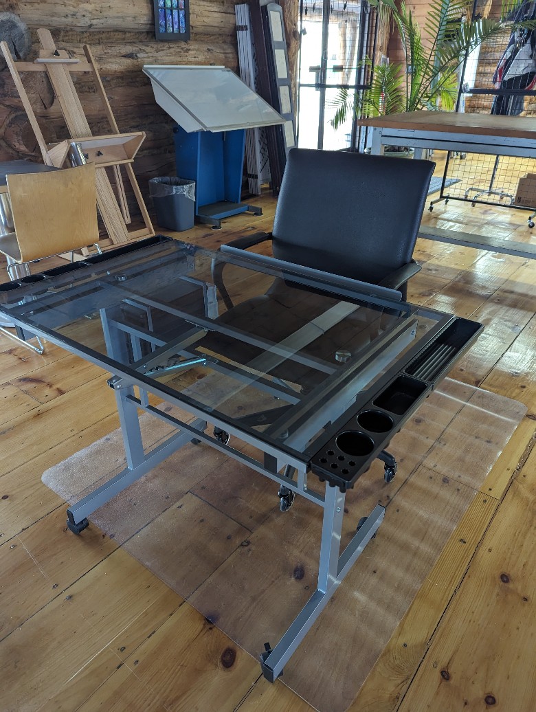 Drafting desk and easels in a log cabin