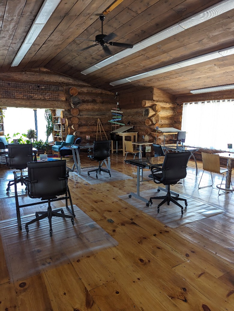 Open creative floor space with desks in a log cabin