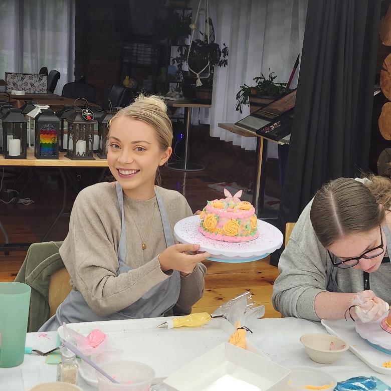 woman holding pink cake she decorated