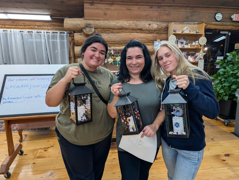 three women holding tiled lanterns