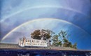 Double rainbow in a blue sky over the Creative Jam sign