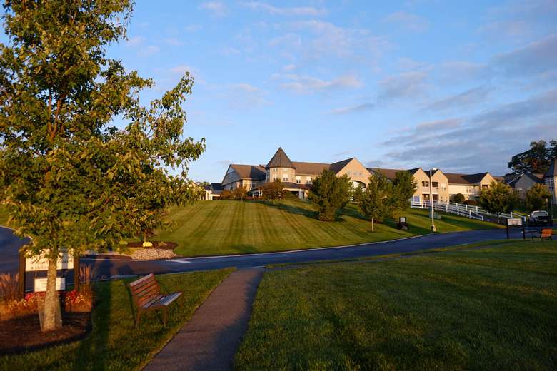 glen eddy as seen from a distance with a vast sloping green lawn and a driveway leading up to the main entrance