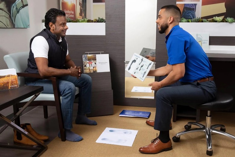 two men discussing custom orthotics