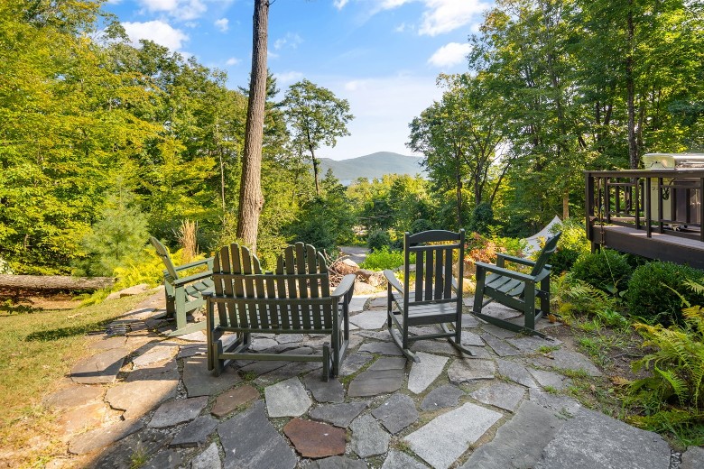 Adirondack chairs around a pit