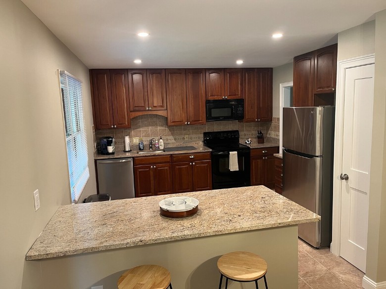 Kitchen with counter seating, fridge, and other appliances