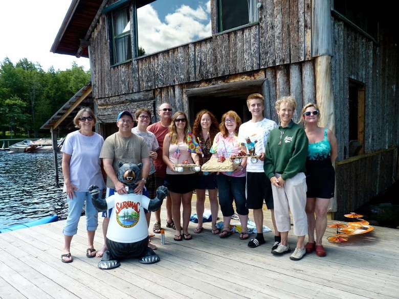 group of people standing by a boathouse