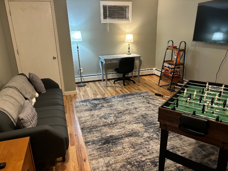 a lounge room with a foosball table and TV