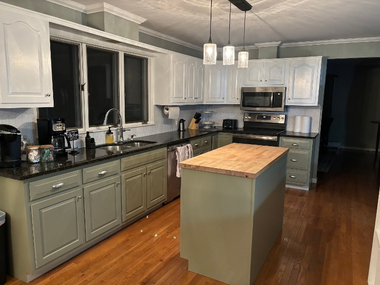 kitchen area with green and white cabinets