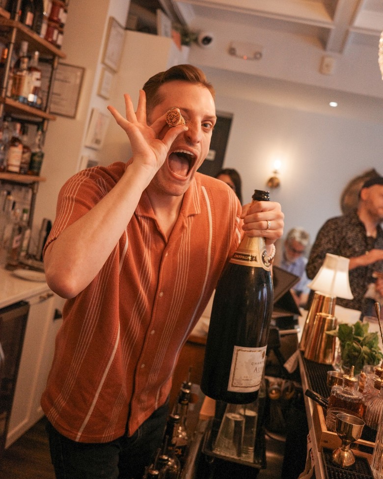 man holding champagne bottle and cork
