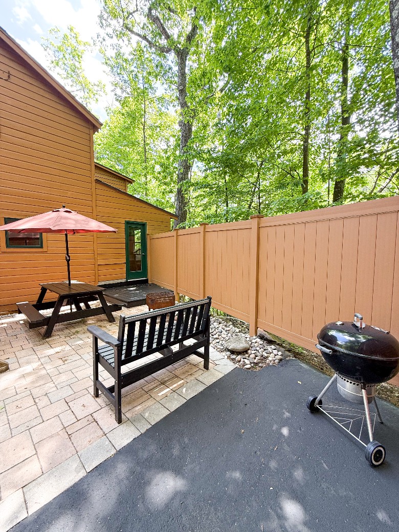 Back patio area with BBQ grill, picnic table, bench and firepit