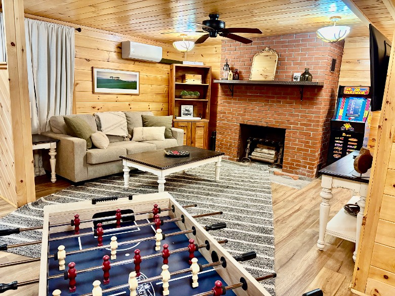 Lower level living area/ game room with foosball table, 2 arcade games and a dart board