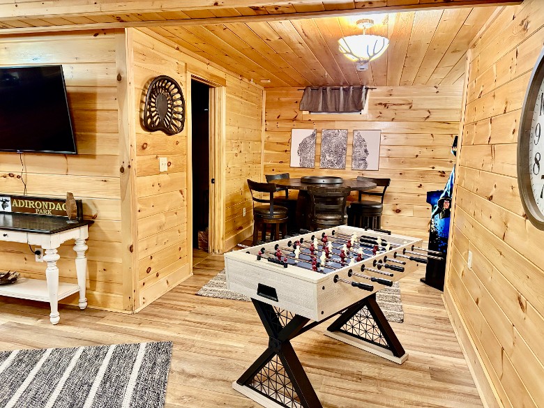 Lower level living area/ game room with foosball table, 2 arcade games and a dart board