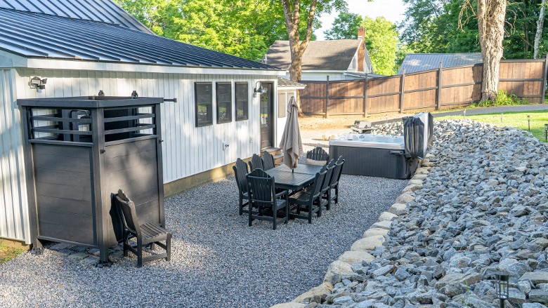 Hot tub, grill, outdoor dining table, and outdoor shower area