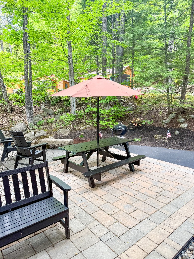 Patio area with BBQ grill, firepit, bench, chairs and a picnic table.