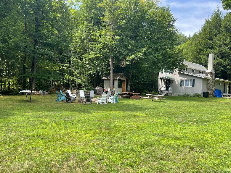 exterior of house with fire pit and adirondack chairs