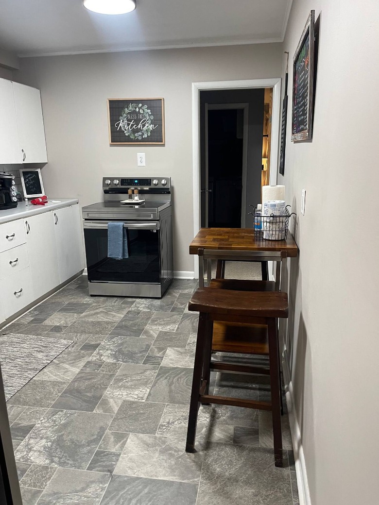 kitchen with stainless steel oven, stools, and tile flooring