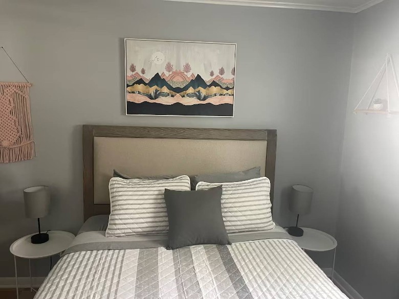 bedroom with a painting above the head