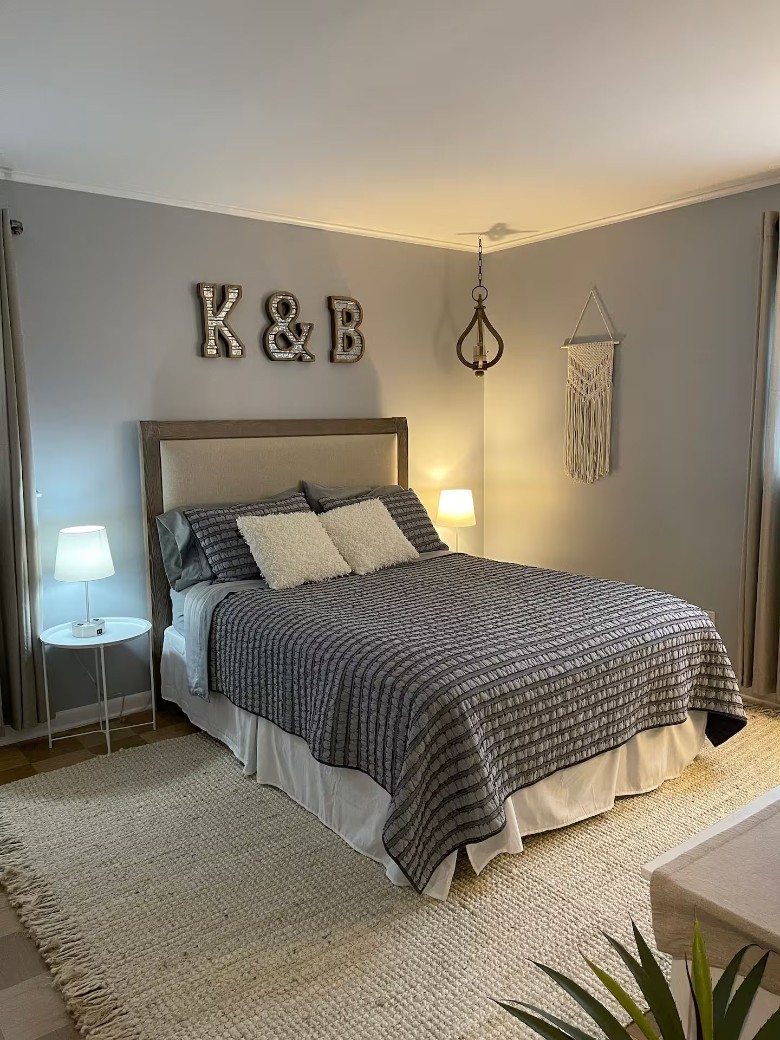 bedroom with a bed, rug, and K and B above the bed on the wall