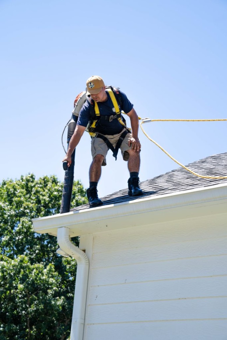 man cleaning gutters