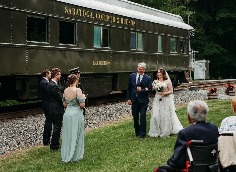 father walking bride down outdoor aisle