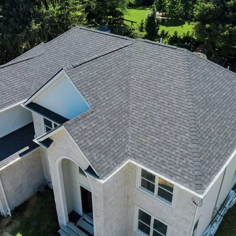 Clean lines, watertight protection, and a roof you can trust. large white home with shingles