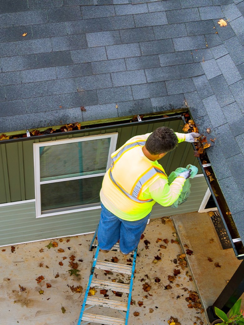 Urban Seamless Gutters is the go-to gutter expert in the Capital Region for installation, repairs, and more. man cleaning out gutters