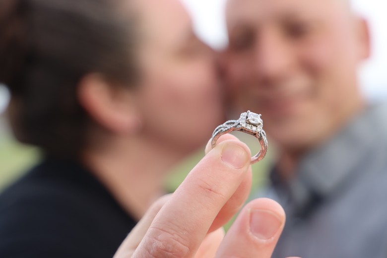 blurred photo of man and woman with women holding engagement ring
