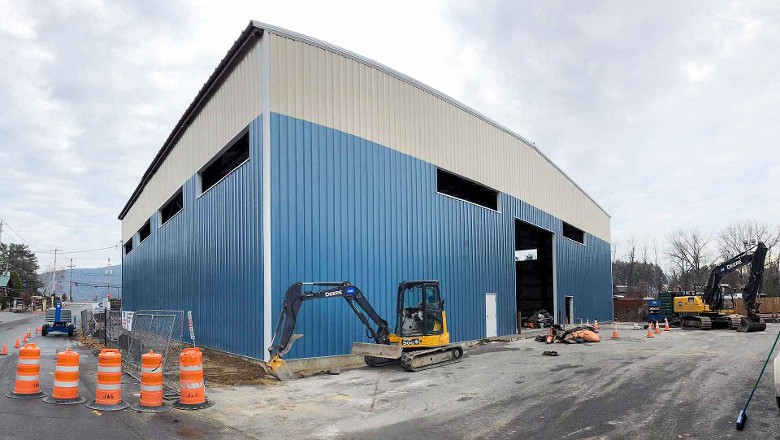 exterior of blue building with excavator outside