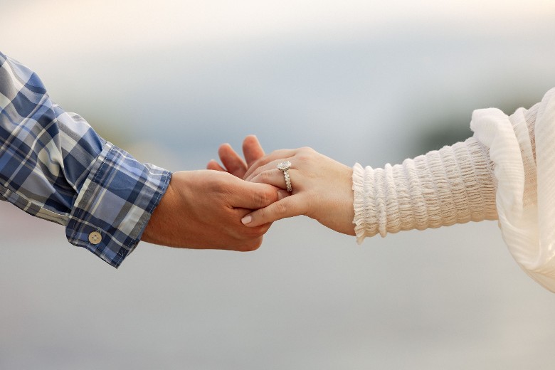 man and woman holding hands, and woman has ring on