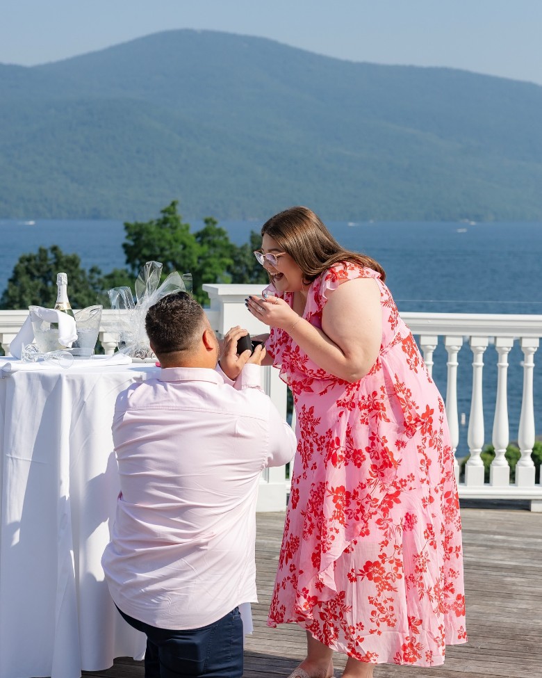 man proposing to woman on lakefront deck