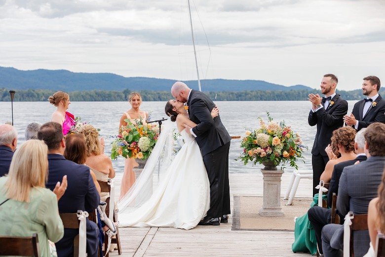 man and woman getting married on dock by a lake