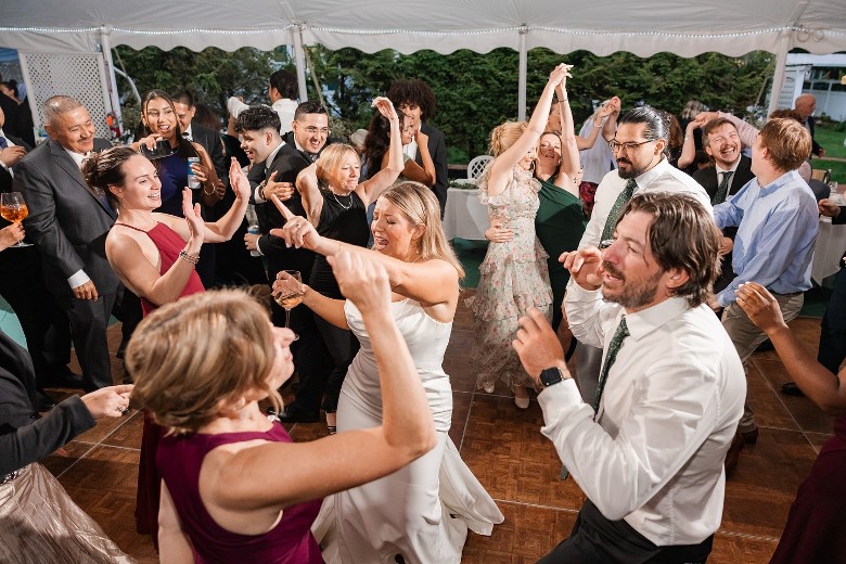 a wedding party dancing under a tent