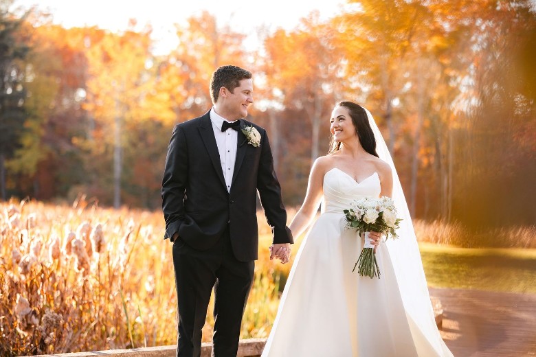 bride and groom outdoors with fall colors on the leaves