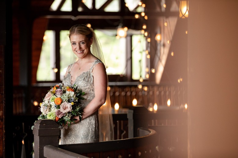 bride holding flowers and standing near rail