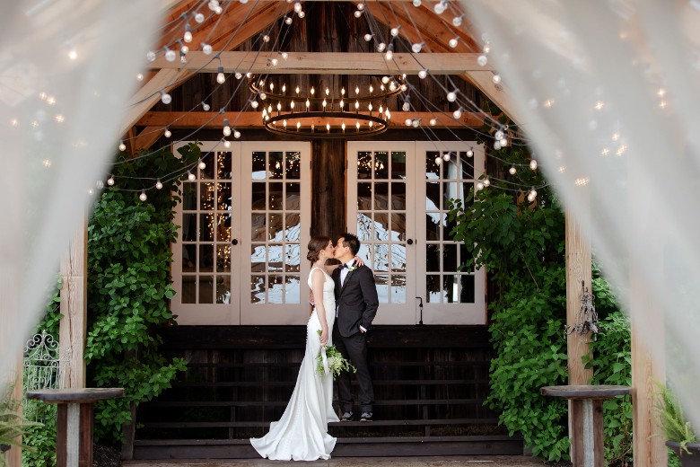bride and groom kissing outdoors on steps of venue