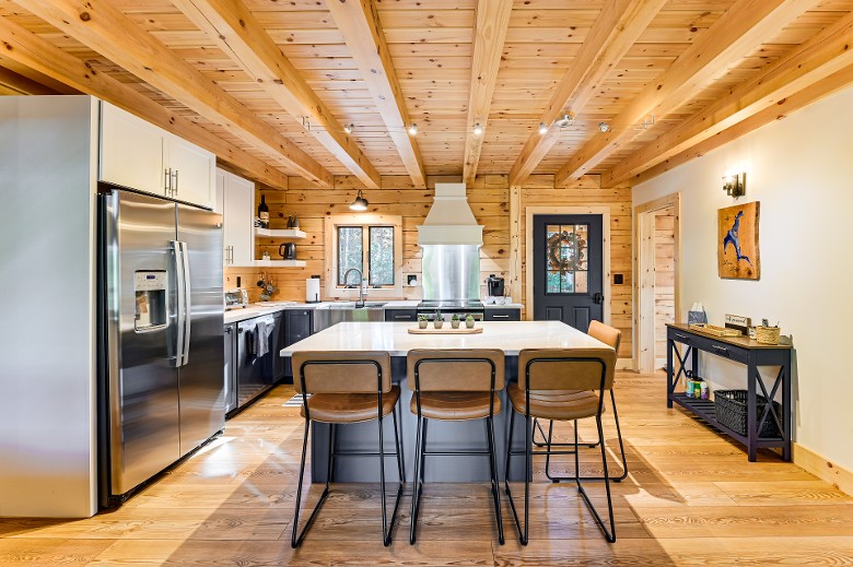 rustic kitchen with appliances and center counter and stools