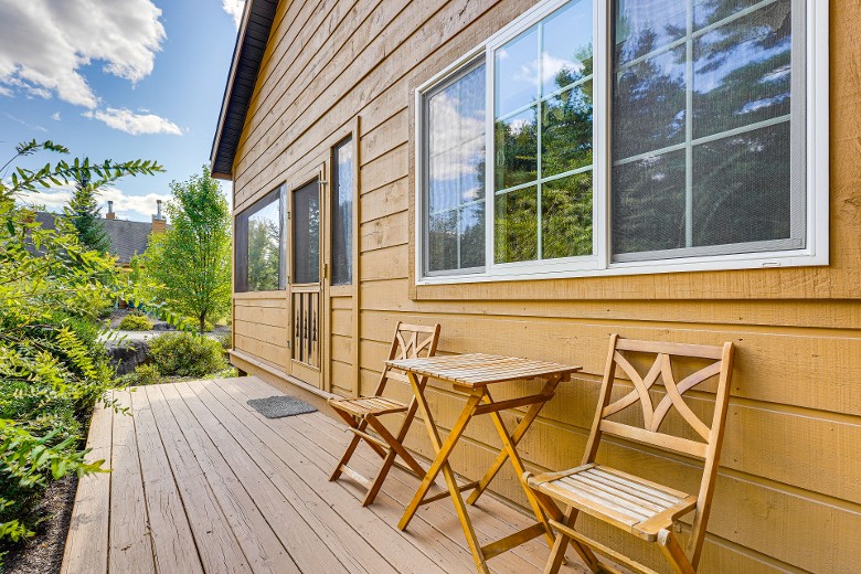 exterior of a rustic wooden home with chairs on the deck