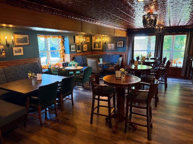 upscale bar lounge with high chairs and tables, and nearby tables
