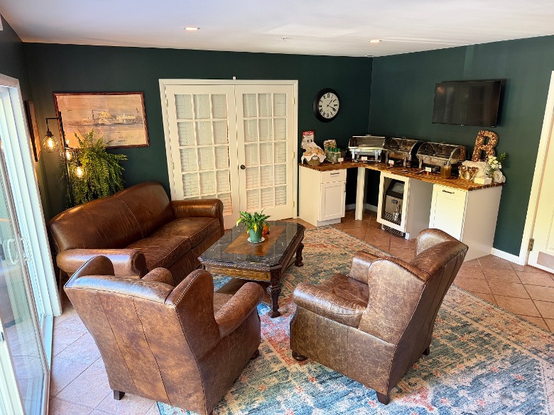 three leather sofas by a table, with buffet food on a nearby counter