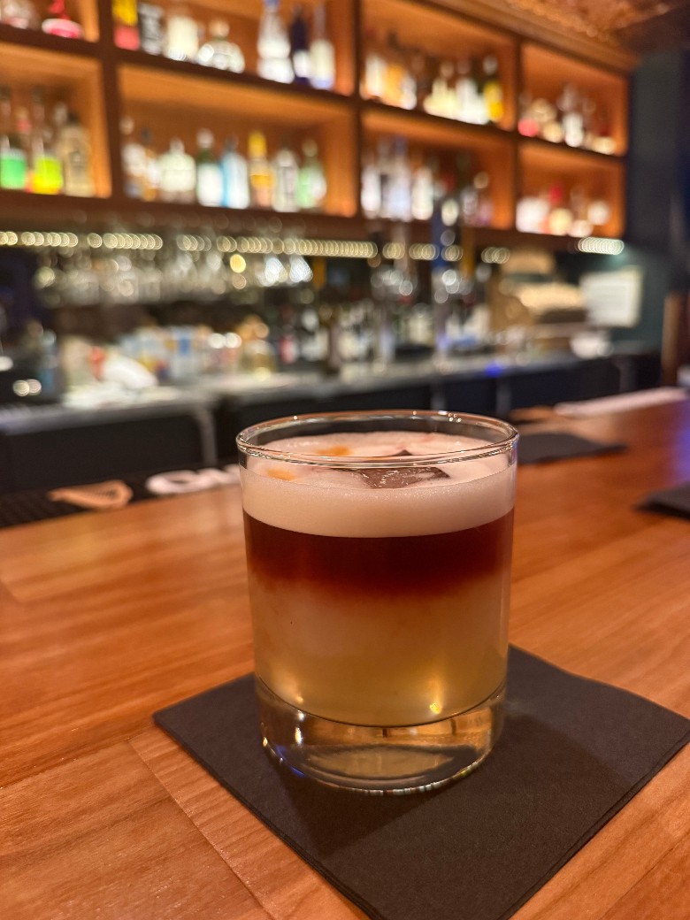 a multi colored cocktail on a black napkin