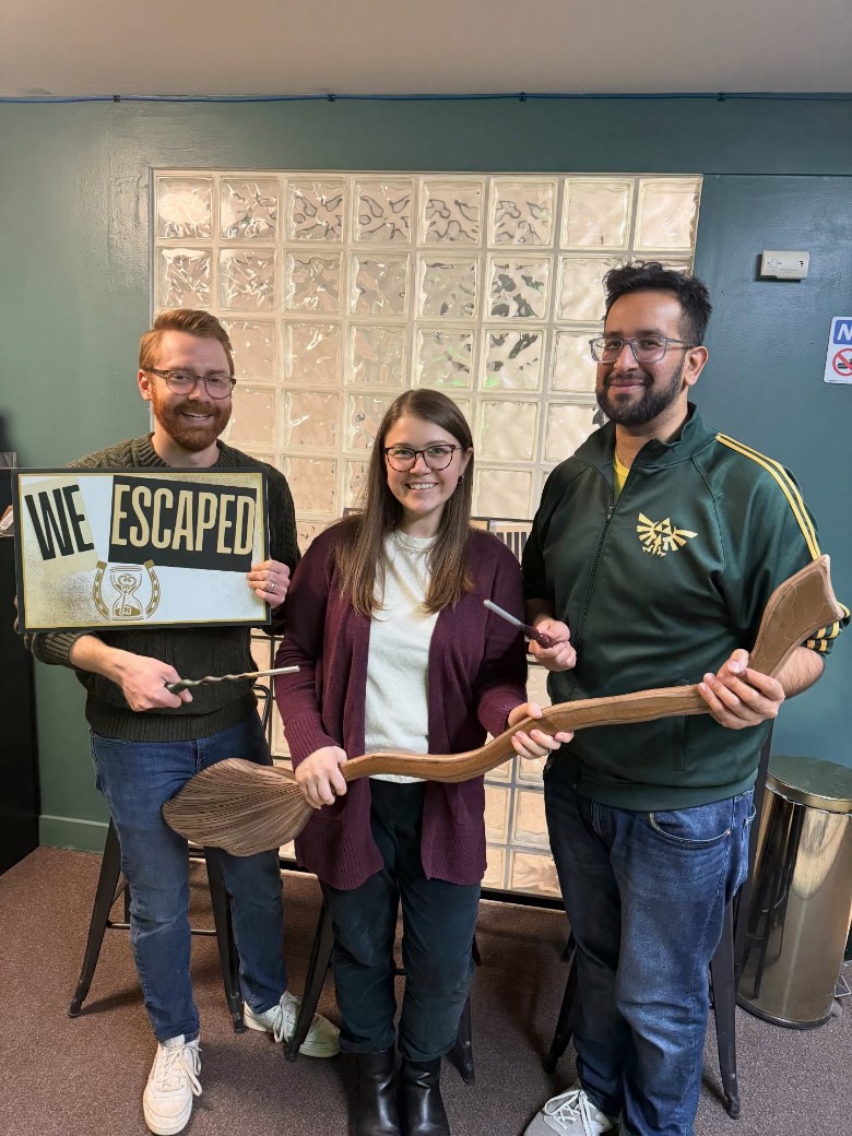 people holding up escape room signs