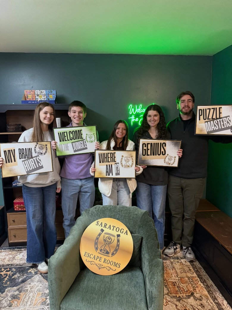 people holding up escape room signs